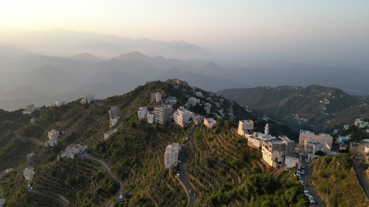 لقطة جوية للبيوت فوق جبال فيفا في جازان وقت الغروب، تصوير درون.