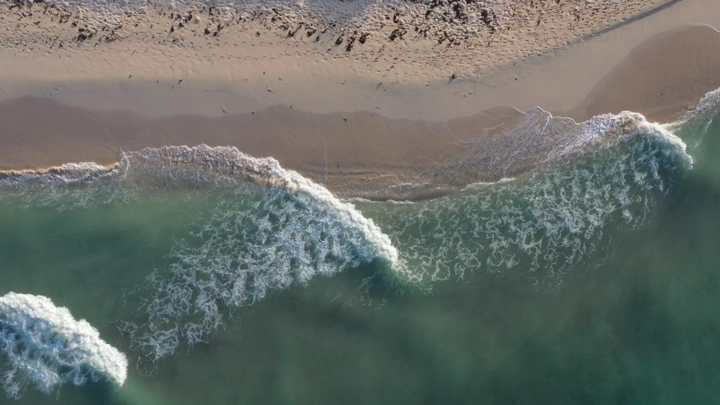 A sandy beach with sea waves in the Asir region, aerial shot.