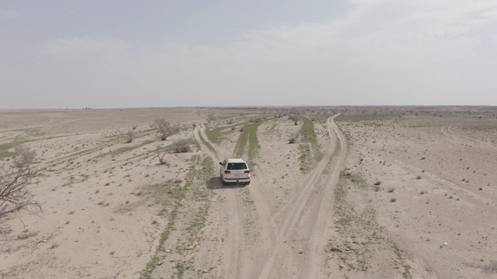 Car driving in northern desert during spring, aerial shot.