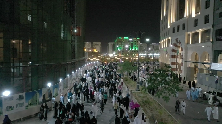 Crowd of people walking at night near Al-Masjid an-Nabawi, overhead shot.