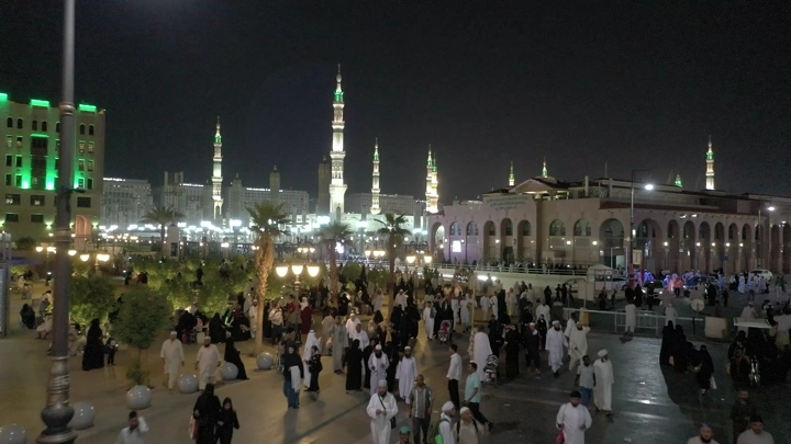 Al-Masjid an-Nabawi in Medina at night, wide shot.