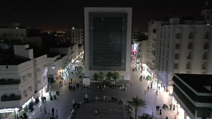 ساحة المدينة المنورة ليلاً مع مبنى مضاء، لقطة جوية.
