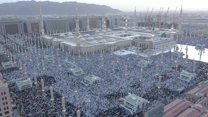 Prophet's Mosque in Medina crowded with worshippers, aerial shot.