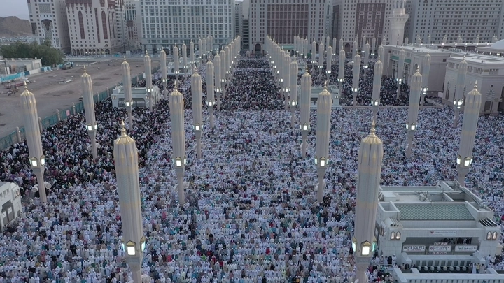 Prophet's Mosque in Medina crowded with worshippers, aerial shot.