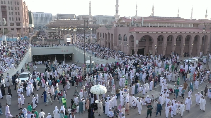 Crowds of people at Al-Masjid an-Nabawi in Medina, aerial shot.
