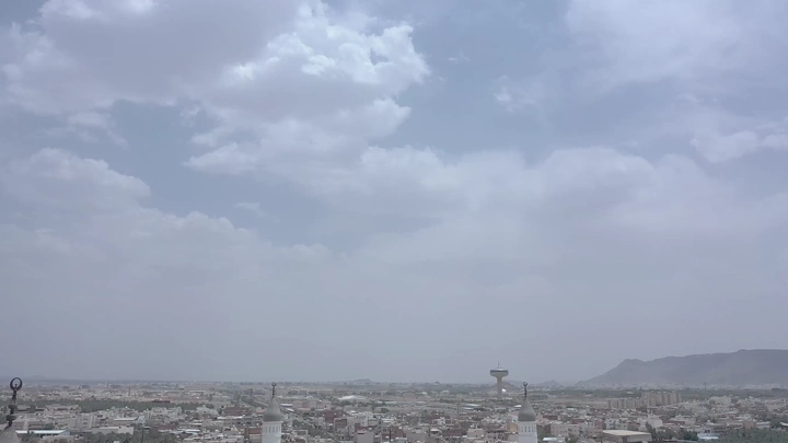 Aerial view of Quba Mosque in Medina under a cloudy sky.
