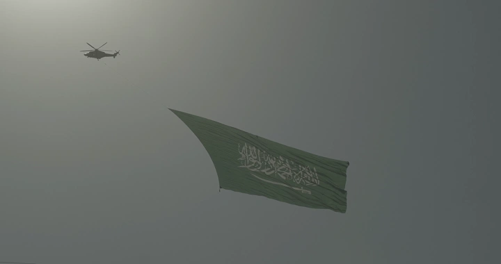 Helicopter carrying a flag in the sky, low-angle shot.