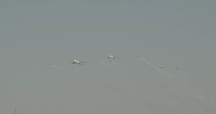 Planes flying in formation during National Day, wide shot.