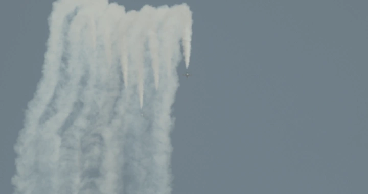 Air show on National Day with planes and smoke in the sky, ground shot.