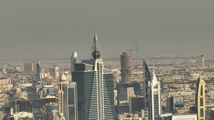 Towers in Riyadh under cloudy sky, aerial shot.