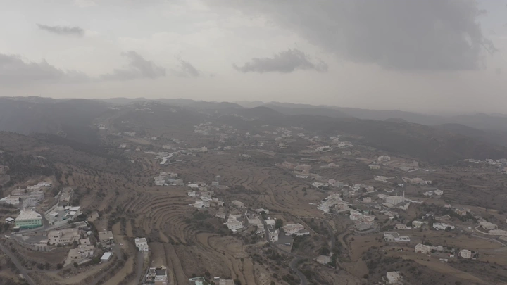 An aerial view of Al-Sahab Park in Abha under a cloudy sky.