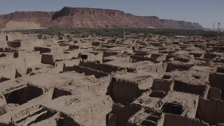 Old town of AlUla under mountains, aerial shot.