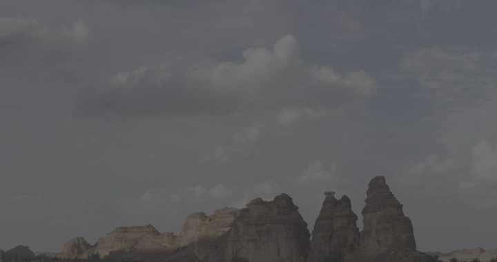 Rock formations in AlUla under a cloudy sky, time-lapse shot.