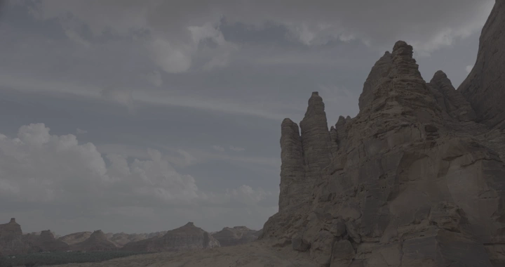 Rock formations in AlUla under a cloudy sky, a time-lapse shot.