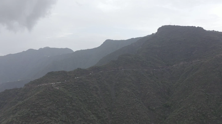 Mountains covered with clouds in Rijal Alma in the Asir region, aerial shot.
