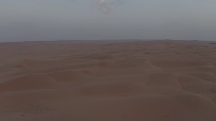 كثبان رملية في الصحراء عند غروب الشمس، لقطة جوية.