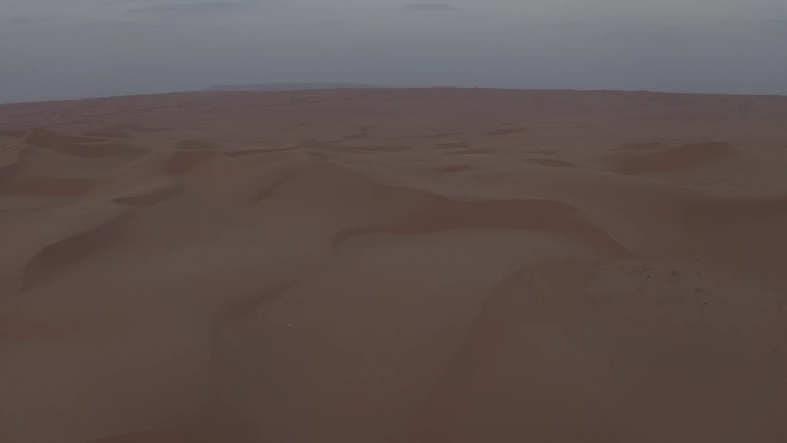 كثبان رملية في الصحراء عند غروب الشمس، لقطة جوية.