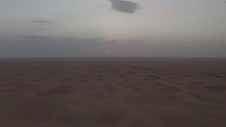 كثبان رملية في الصحراء عند غروب الشمس، لقطة جوية.