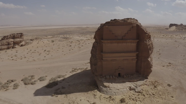 الحجر بوابة صخرية منحوتة على جبل في مدائن صالح بالعلا، لقطة جوية نهارية.