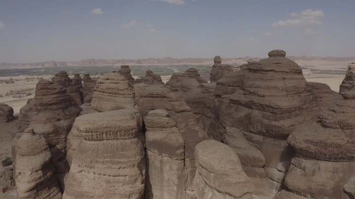 Rock formations in AlUla mountains, daytime aerial shot.