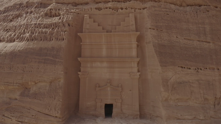 الحجر بوابة صخرية منحوتة على جبل في مدائن صالح بالعلا، لقطة جوية نهارية.