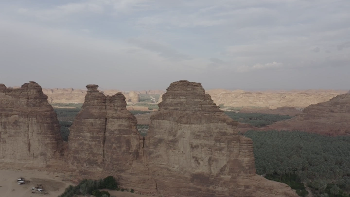 تكوينات صخرية في العلا مع مزارع نخيل، لقطة جوية.