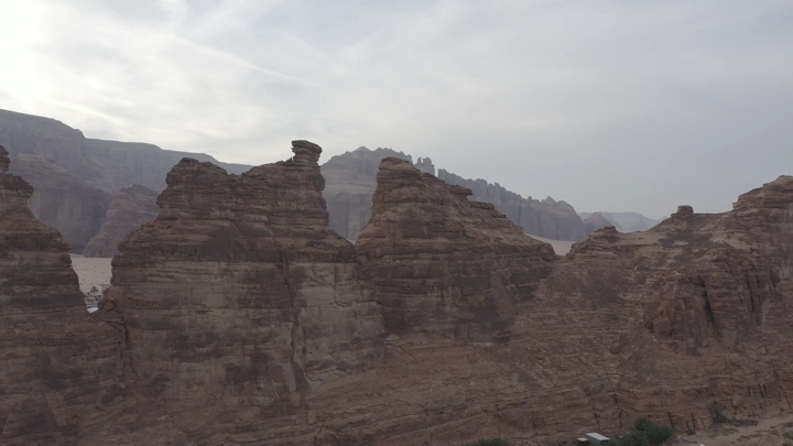 Rock formations in AlUla under cloudy sky, aerial shot.