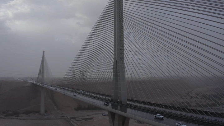 الجسر المعلق في الرياض تحت السماء الغائمة، لقطة من زاوية مرتفعة.