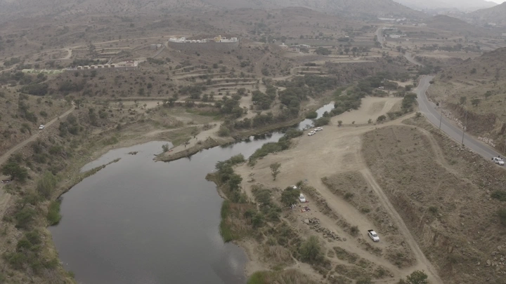 منظر جوي لسد ضبوعي في أبها، يظهر التضاريس المحيطة والطريق المجاور.