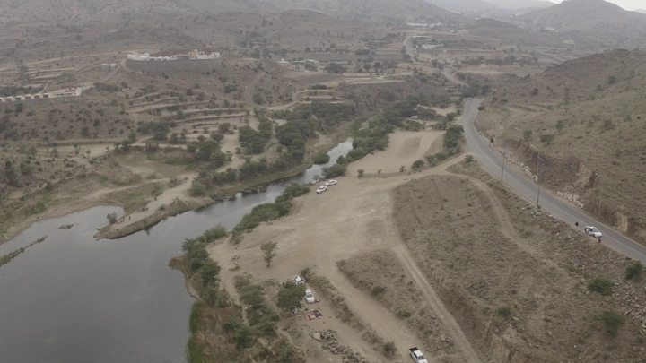 منظر جوي لسد ضبوعي في أبها، يظهر التضاريس المحيطة والطريق المجاور.
