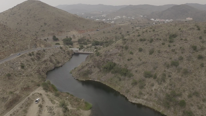 سد ضبوعي محاط بالتلال في أبها، لقطة جوية.