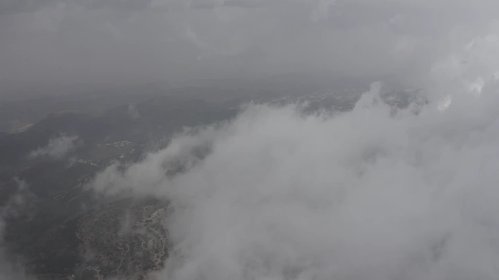 Al-Soudah mountains covered in clouds, aerial shot.
