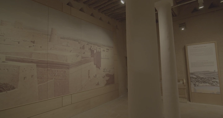 Inside Al-Masmak Palace in Riyadh, a historical scene on the wall, dim lighting.