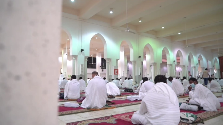حجاج يجلسون في مسجد خلال الحج، لقطة داخلية.
