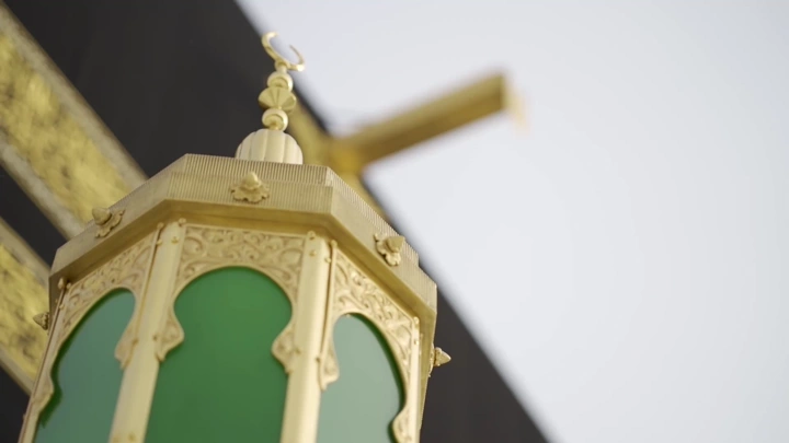 فانوس ذهبي وزخارف خضراء في الحرم المكي، لقطة قريبة.