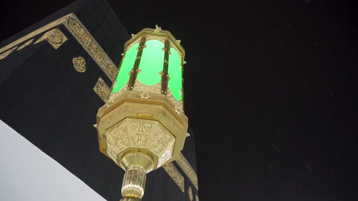 فانوس مضاء أمام الكعبة ليلاً، لقطة من الأسفل.