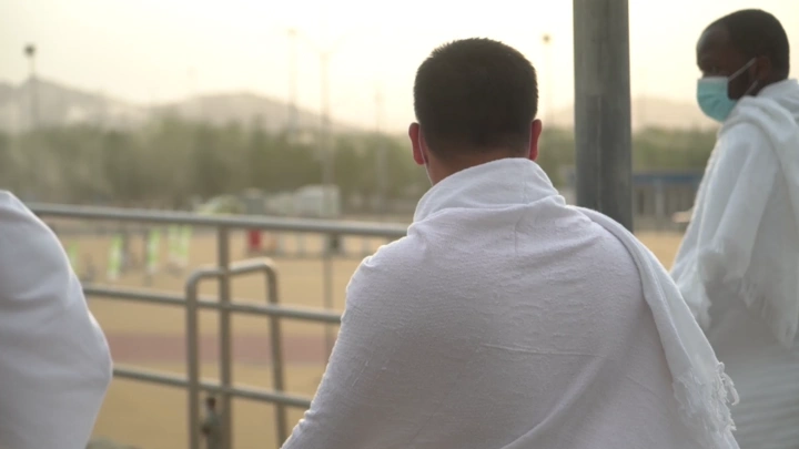 حجاج يرتدون الإحرام في موقع الحج، لقطة نهارية.