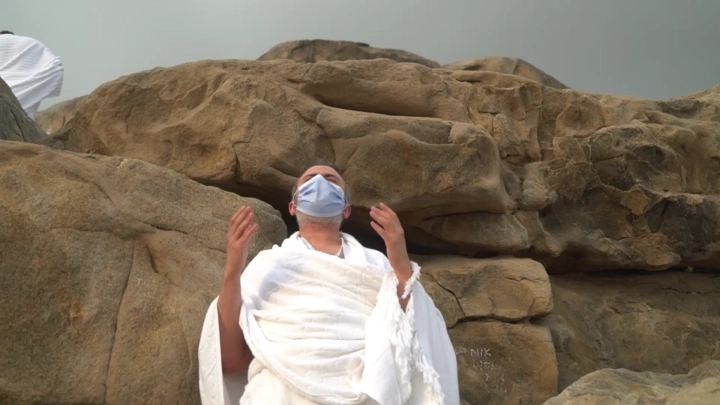 شخص يرتدي إحرام يدعو على جبل عرفات، لقطة مقربة.