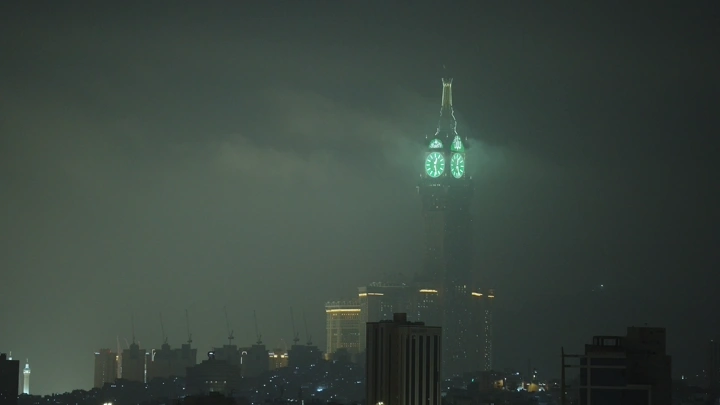 برج الساعة في مكة ليلاً، لقطة من بعيد.