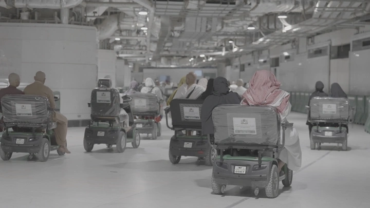 مجموعة من الأشخاص على عربات كهربائية في ممر الحرم، لقطة داخلية.