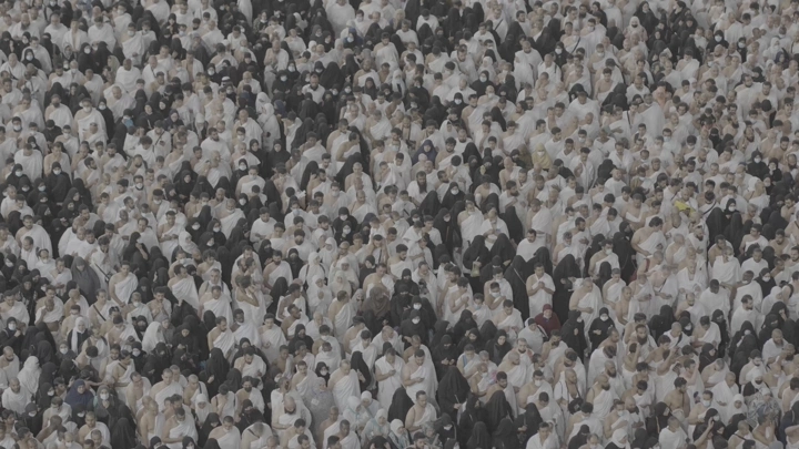 حشد من الناس في الحرم يرتدون ملابس الإحرام، لقطة علوية.