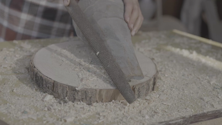 نجار يعمل على قطعة خشب في ورشة، لقطة مقربة.