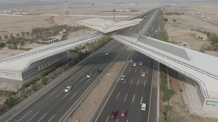 بوابة كبيرة فوق طريق سريع في منطقة صحراوية، لقطة جوية.