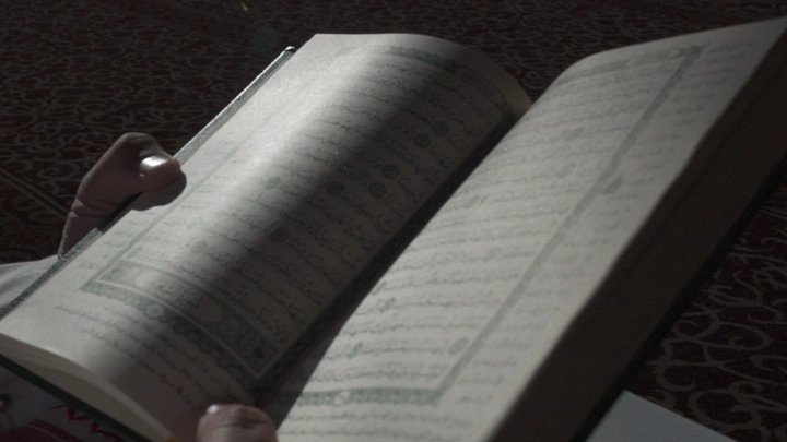 قراءة القرآن في ضوء خافت، لقطة قريبة.