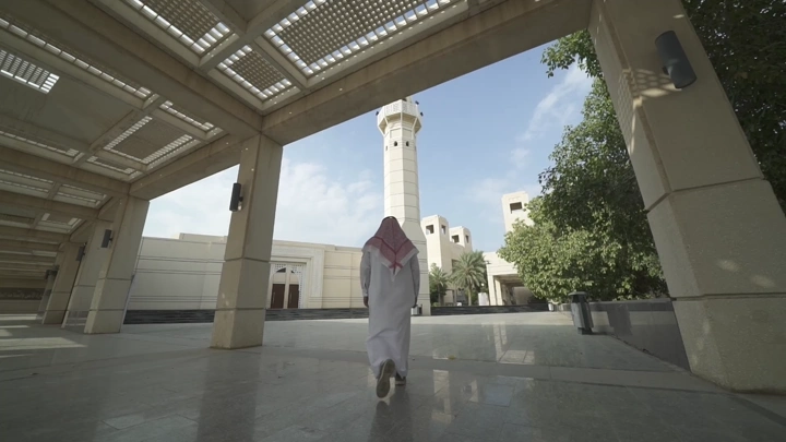 شخص يسير في حرم جامعة حديثة، لقطة واسعة.