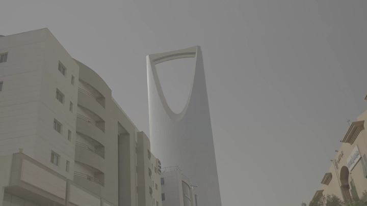 برج في الرياض تحت سماء غائمة، لقطة من الأسفل.