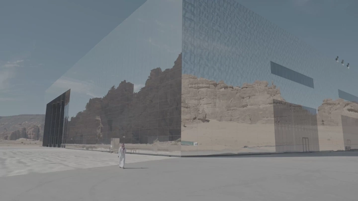 مبنى زجاجي يعكس الصخور في العلا، لقطة نهارية.