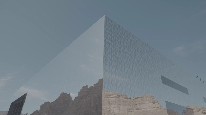 مبنى زجاجي يعكس الجبال في العلا، لقطة نهارية.