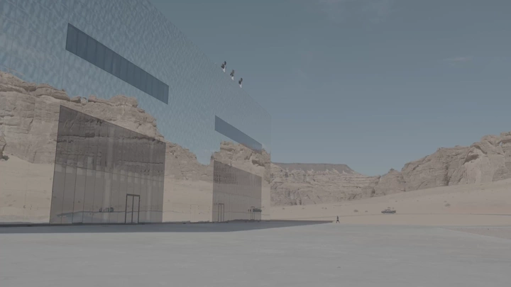 مبنى زجاجي يعكس الجبال في العلا، لقطة نهارية.