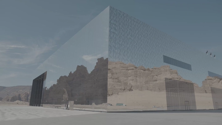 مبنى زجاجي يعكس الجبال في العلا، لقطة نهارية.